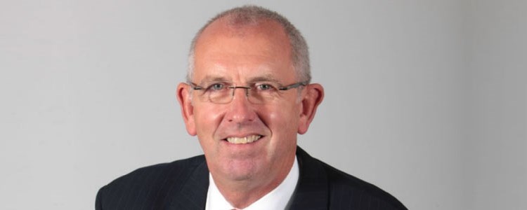 headshot image of chairman graham watson in a suit smiling