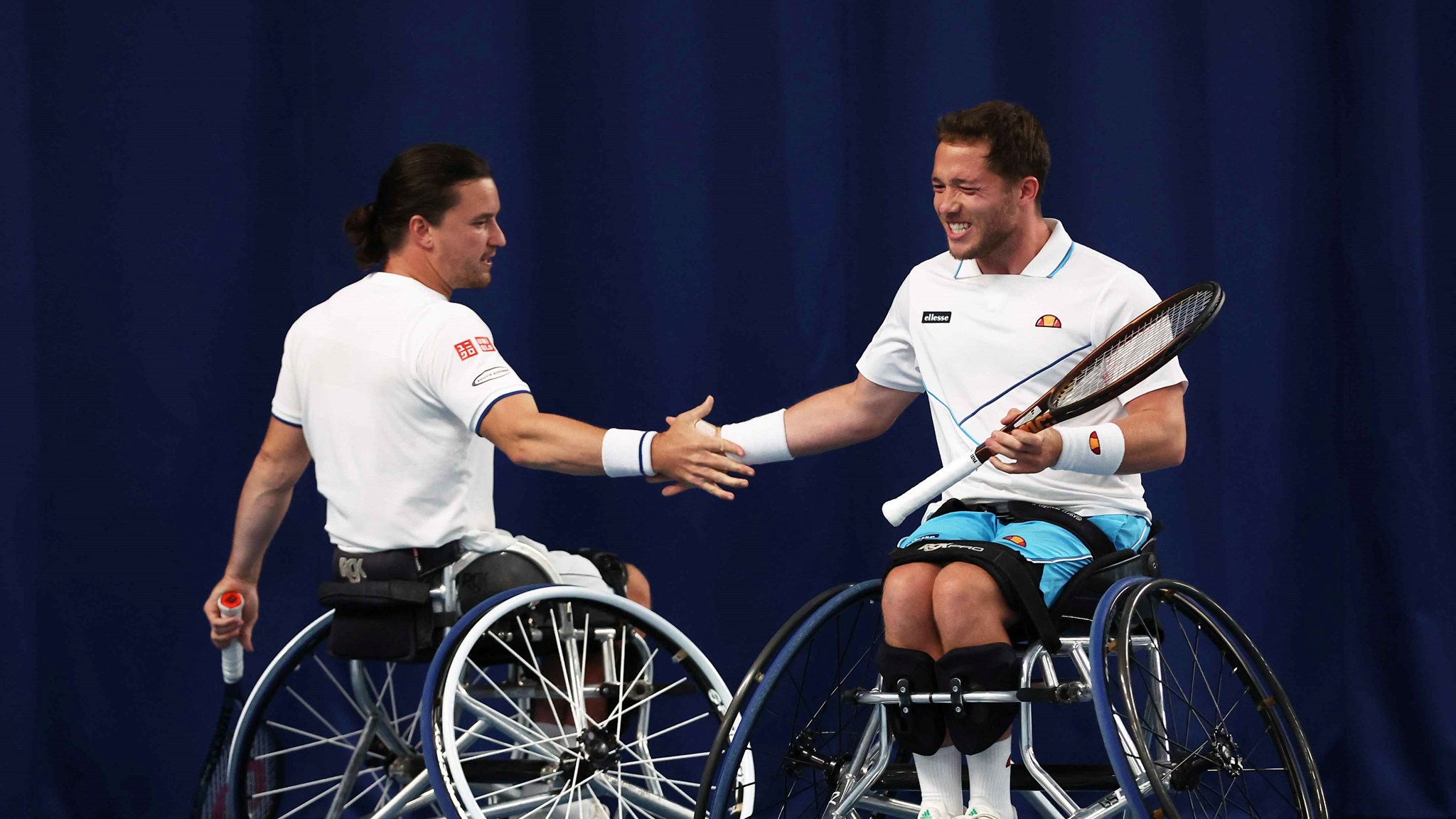 Wheelchair tennis players Alfie Hewett and Gordon Reid high fiving on court at the Lexus British Open 