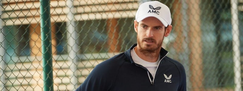 close up image of andy murray on court wearing amc branded jumper and hat