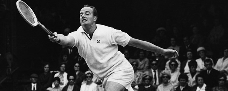 Bobby Wilson returning a shot in a tennis match with people watching