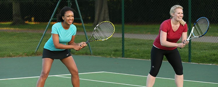 Two female tennis players smiling in doubles