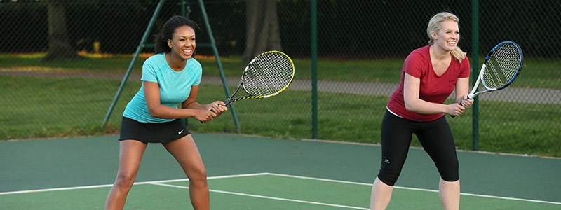 Two female tennis players smiling in doubles