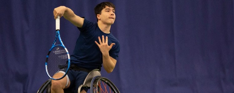 Dahnon Ward hitting a serve on the tennis court