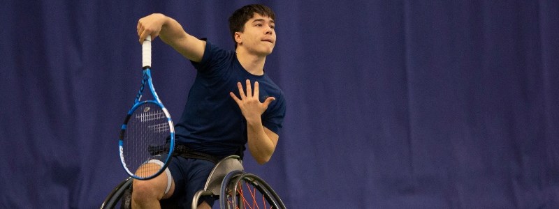 Dahnon Ward hitting a serve on the tennis court