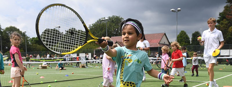 Young boy holding a tennis racket at the 'Middle Sunday' event