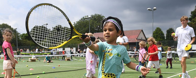 Young boy holding a tennis racket at the 'Middle Sunday' event