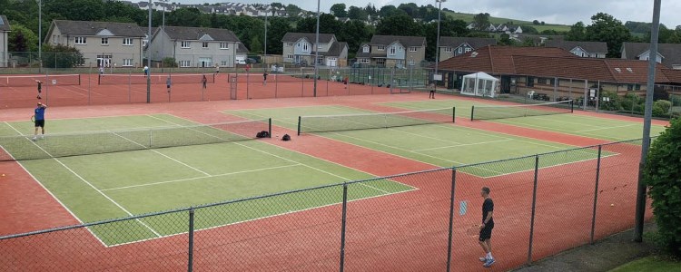 image of grass tennis courts at brought ferry tennis club with two players  playing a match on one of the courts