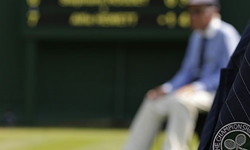 Blurry picture of court with focus on wimbledon badge on officials jacket