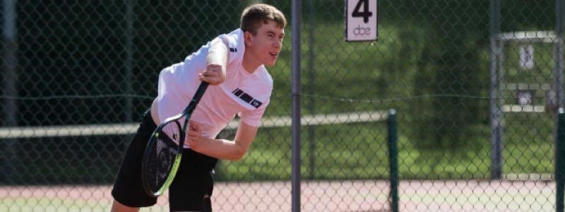 ben hudson serving in a match at the four nation junior championships