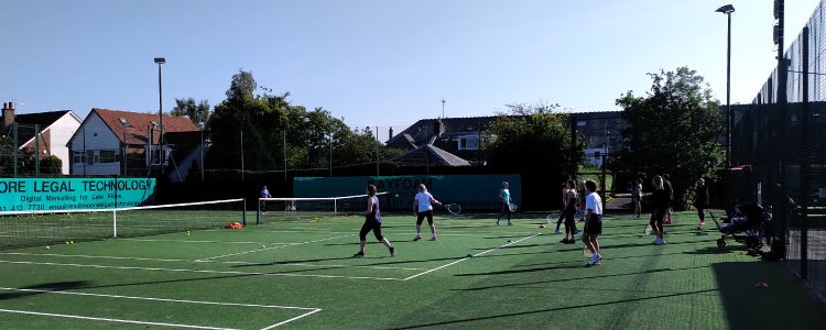 adult players training  on two courts at giffnock tennis club