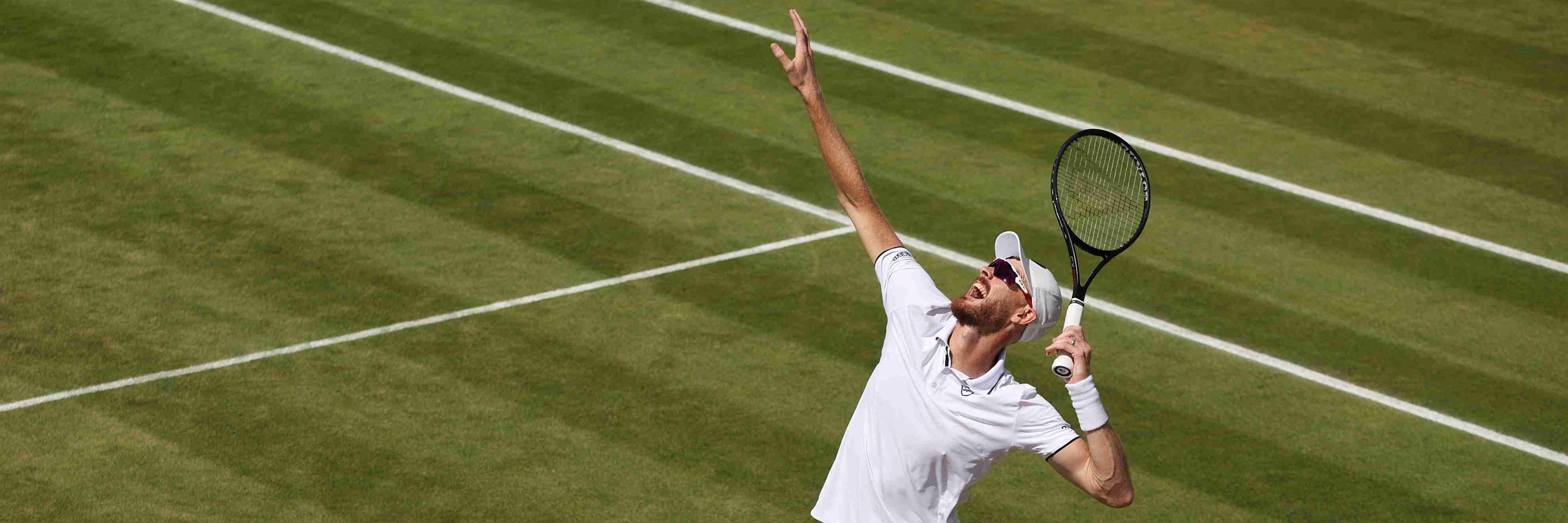 British doubles star Jamie Murray preparing to hit a serve on court at Wimbledon