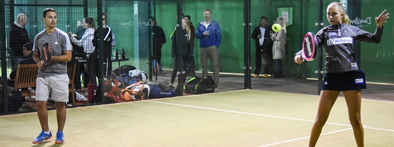 A male and a female playing padel