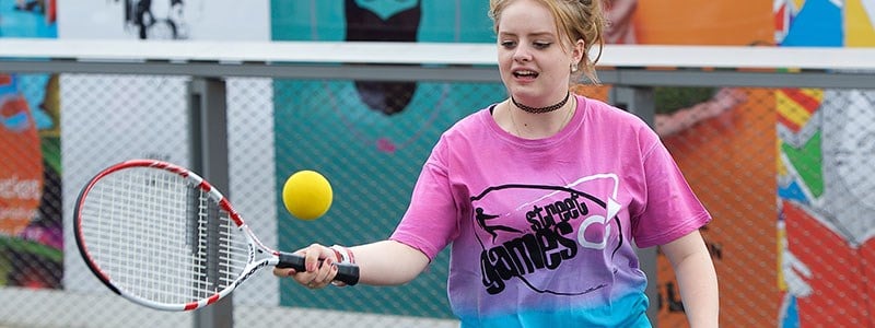 Young girl hits a forehand with streetgames top on
