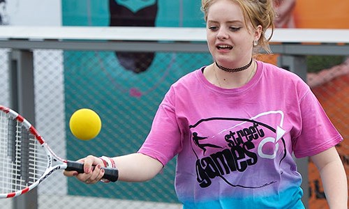 Young girl hits a forehand with streetgames top on