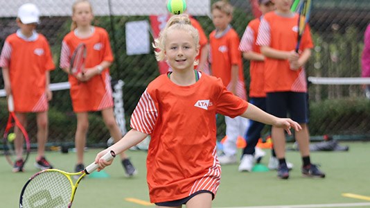 A girl runs to hit a ball as part of the LTA Youth Start programme