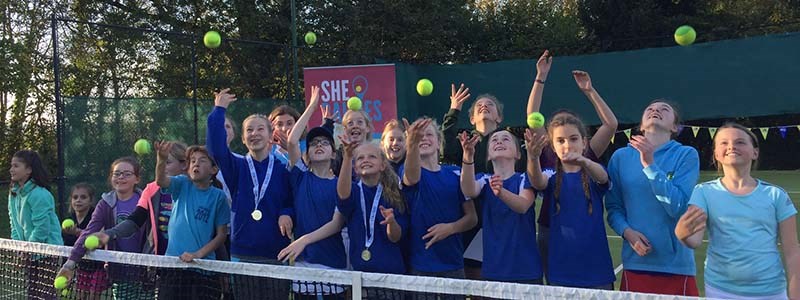 Young girls at Bishop Sutton Tennis club throwing up tennis balls