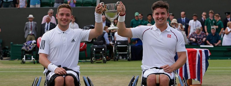 Alfie Hewett and Gordon Reid both smiling and holding a trophy