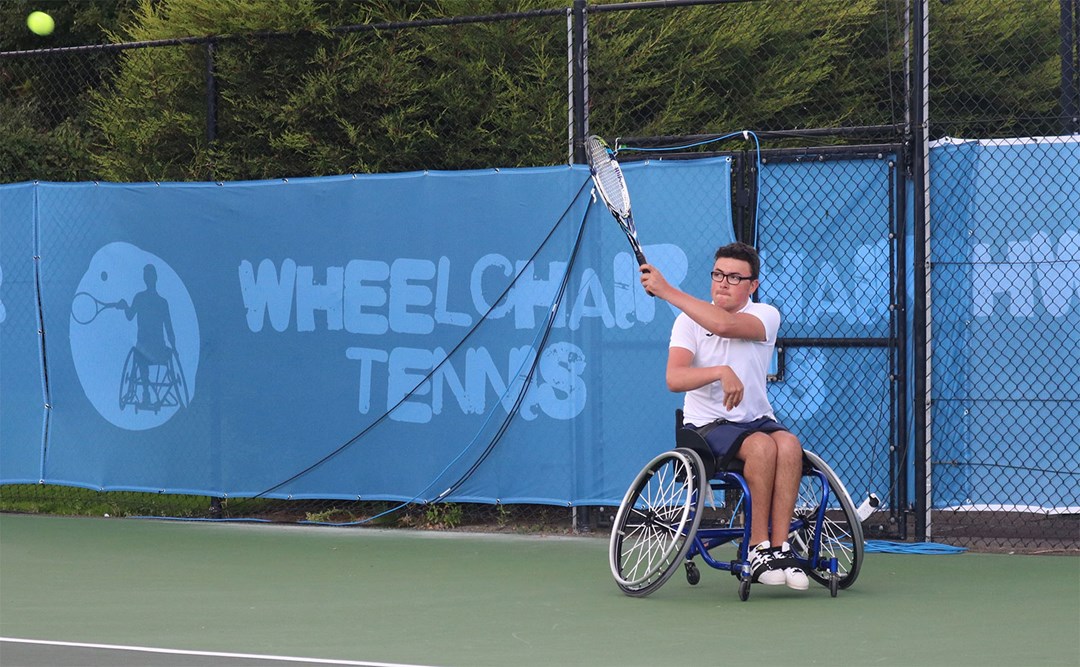 Junior tennis player in wheelchair hits a forehand at the School Games