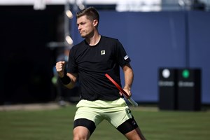 British tennis player Neal Skupski clenching his fist and holding his tennis racket in one hand while on court at the Lexus Eastbourne Open