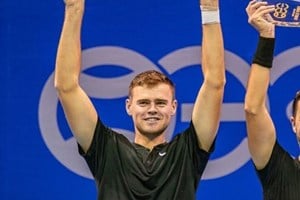 David Stevenson lifting a doubles trophy above his head in celebration
