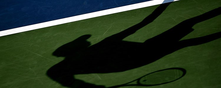 a shadow of a tennis player on a court