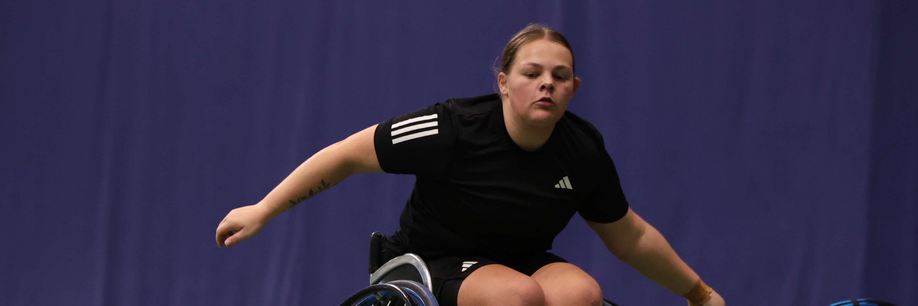 Wheelchair tennis player Ruby Bishop sat in her wheelchair while preparing to hit a forehand on court