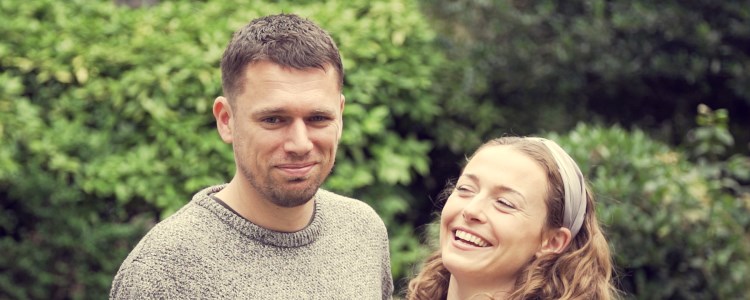 close up image of steve and elle standing together with steve smiling and elle laughing