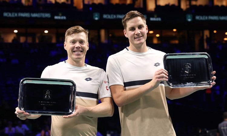 Harri Heliovaara and Henry Patten holding the Rolex Paris Masters title