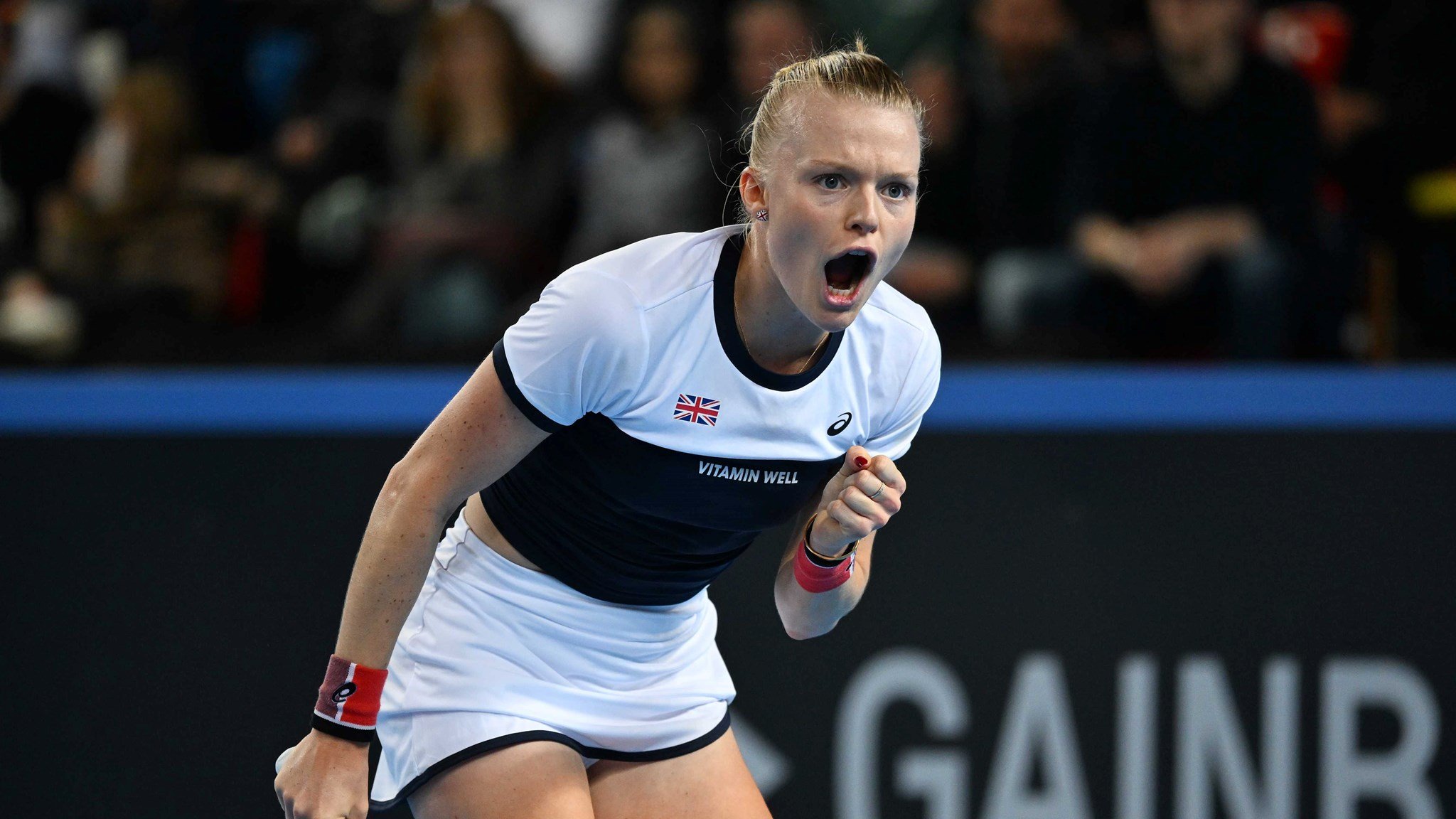 Harriet Dart roars in celebration and clenches her fist on court at the Billie Jean King Cup