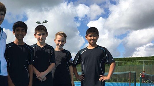Sue Rich with four young boys on a tennis court