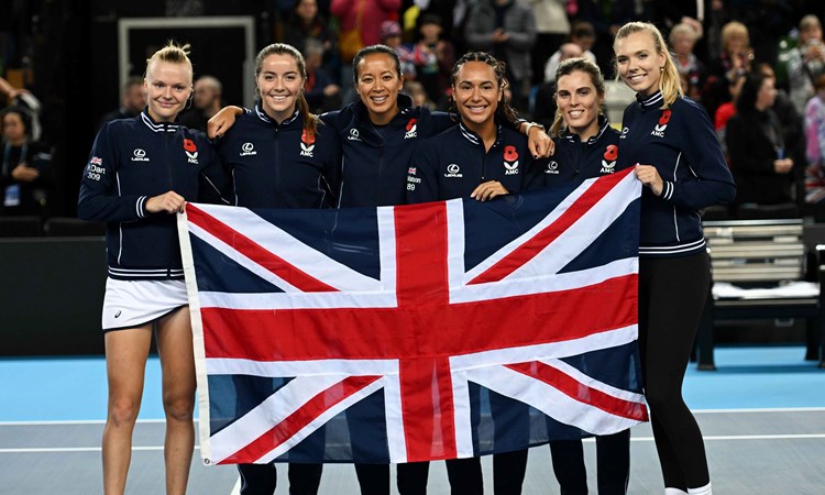 Harriet Dart, Heather Watson, Anne Keothavong, Maia Lumsden, Jodie Burrage and Katie Boulter holding the flag of Great Britain on court after qualifying for the 2024 Billie Jean King Cup Qualifiers