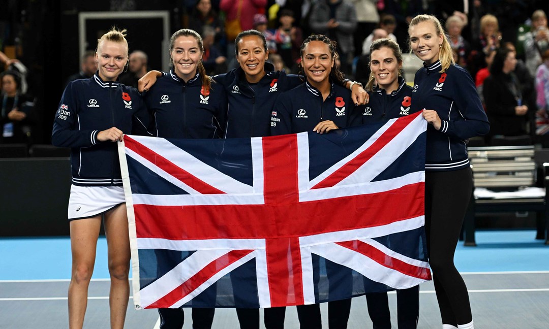 Harriet Dart, Heather Watson, Anne Keothavong, Maia Lumsden, Jodie Burrage and Katie Boulter holding the flag of Great Britain on court after qualifying for the 2024 Billie Jean King Cup Qualifiers