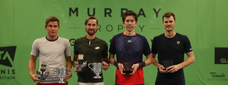 jamie murray and three other players holding trophies in hand in front of murray trophy sign