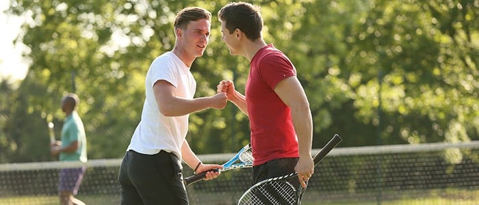 Two men fist pumping while playing tennis