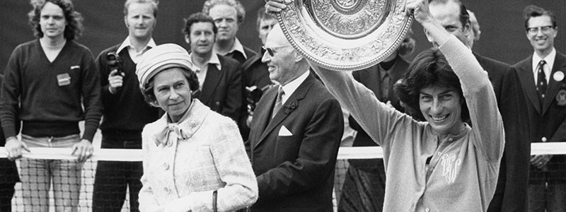 black and white image of virginia wade holding winners trophy and the queen on the left of her
