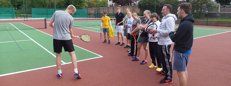 luke house on court coaching players on how to swing the racket
