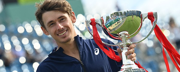 Alex de Minaur holding the champions trophy at Eastbourne