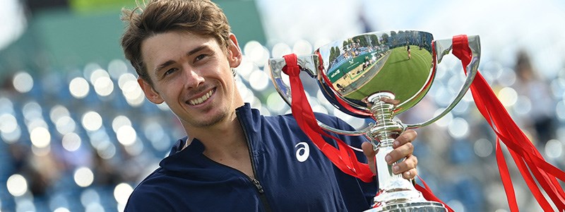 Alex de Minaur holding the champions trophy at Eastbourne