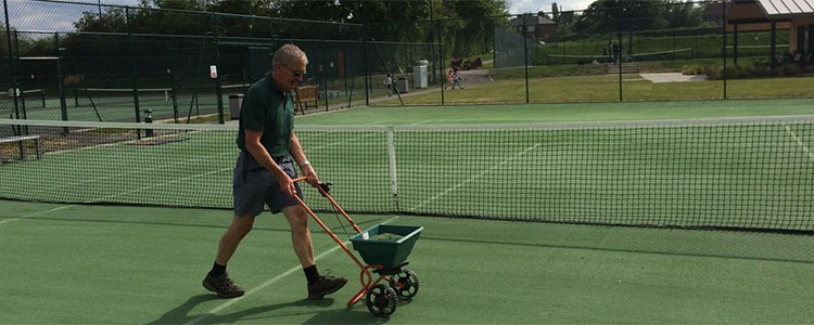 ken thomas pushing line marking machines on outdoor grass court