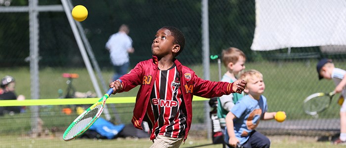 Small boy hitting a foam ball in the air