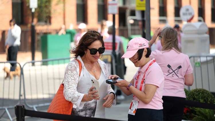A female volunteer scanning a woman's ticket on her phone as she enters the HSBC Championships