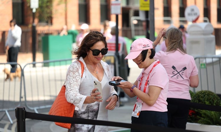 A female volunteer scanning a woman's ticket on her phone as she enters the HSBC Championships