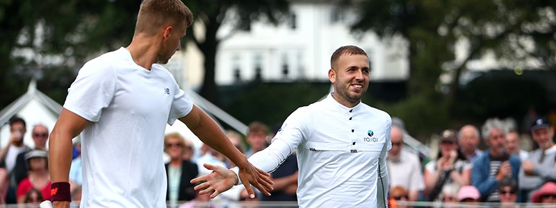 Dan Evans and Lloyd Glasspool high five during a doubles match