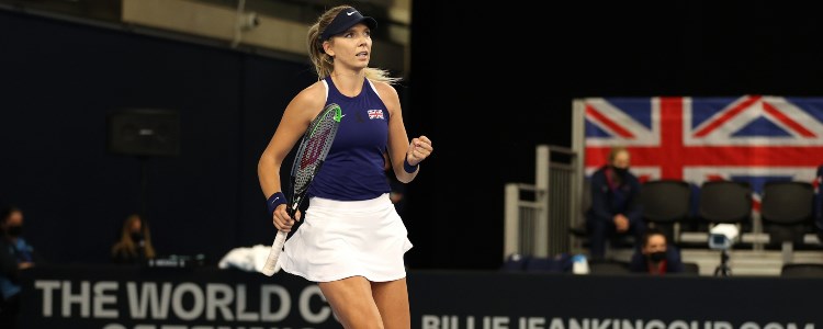 Katie Boulter celebrating on a tennis court with her tennis racket in front of an audience
