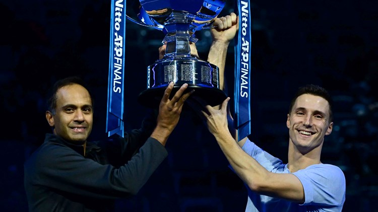 Rajeev Ram and Joe Salisbury both holding the Nitto ATP trophy while smiling on court