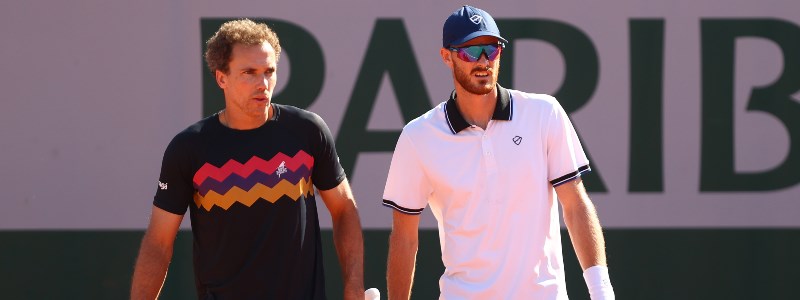 Jamie Murray in sunglasses with Bruno Soares on a tennis court