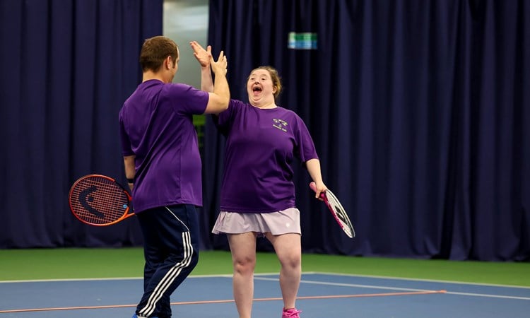 Two players high fiving at the 2025 Learning Disability Tennis National Finals