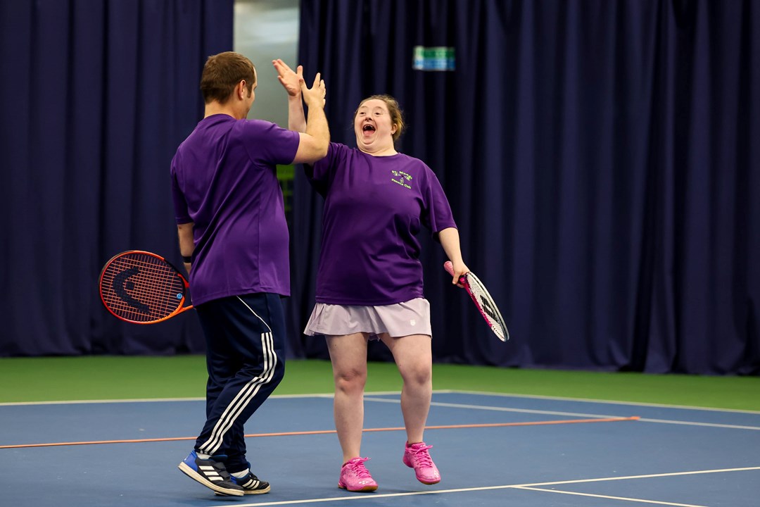 Two players high fiving at the 2025 Learning Disability Tennis National Finals