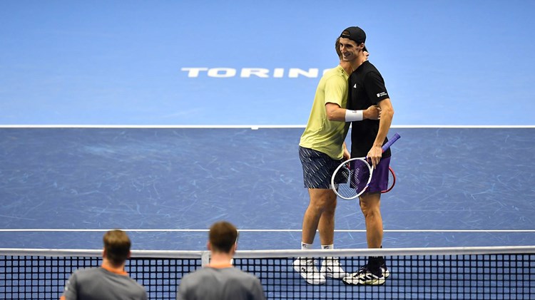 Neal Skupski and Joe Salisbury hug on court after winning a match at the Nitto ATP Finals