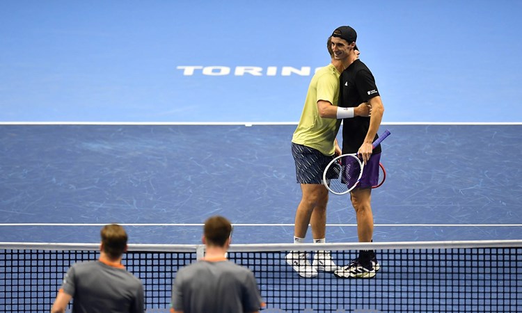 Neal Skupski and Joe Salisbury hug on court after winning a match at the Nitto ATP Finals